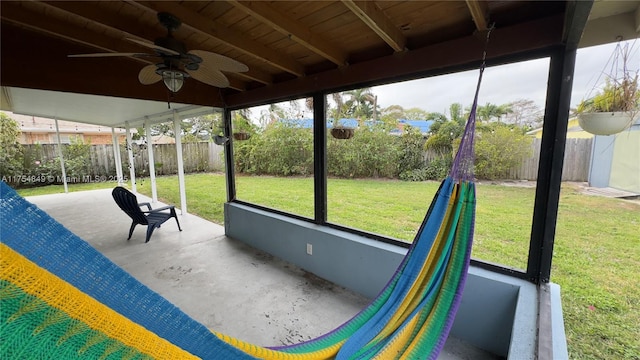 unfurnished sunroom featuring a ceiling fan