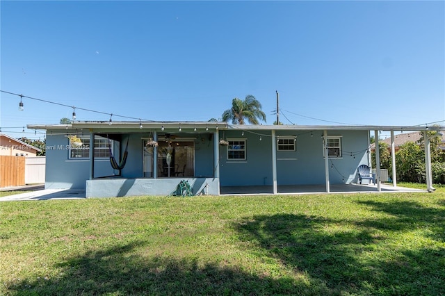 back of property with stucco siding, fence, a patio, and a yard