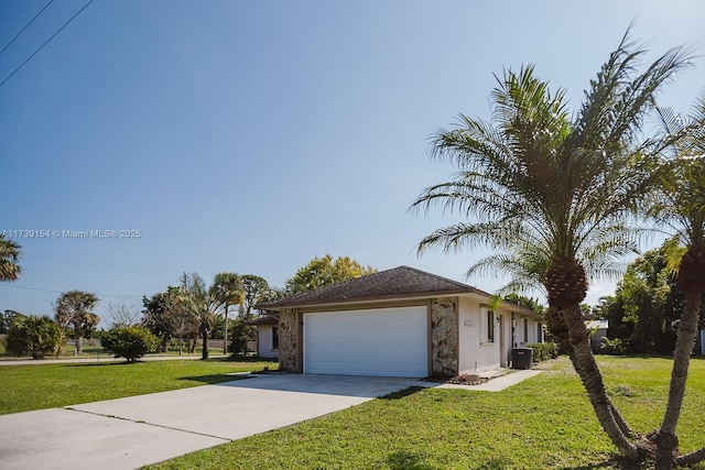 view of front of house featuring a garage, a front yard, driveway, and central air condition unit