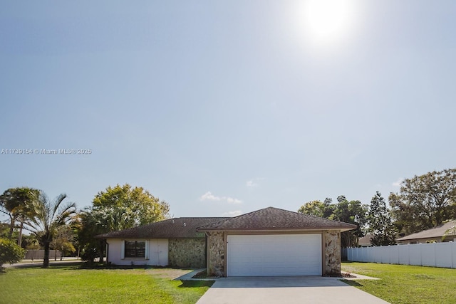 view of front of house featuring driveway, a garage, fence, and a front yard