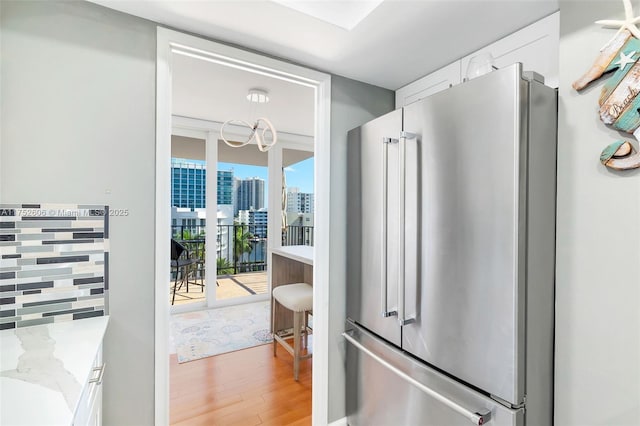 bathroom with a notable chandelier, a view of city, floor to ceiling windows, and wood finished floors