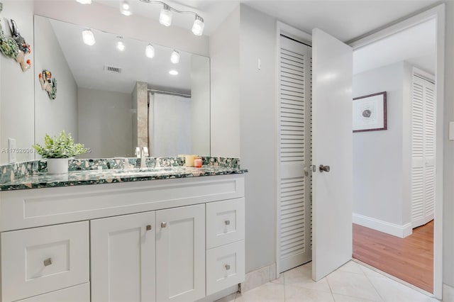 full bathroom with a closet, visible vents, vanity, and tile patterned floors