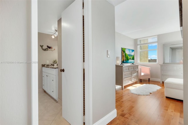 bathroom with baseboards, wood finished floors, and vanity