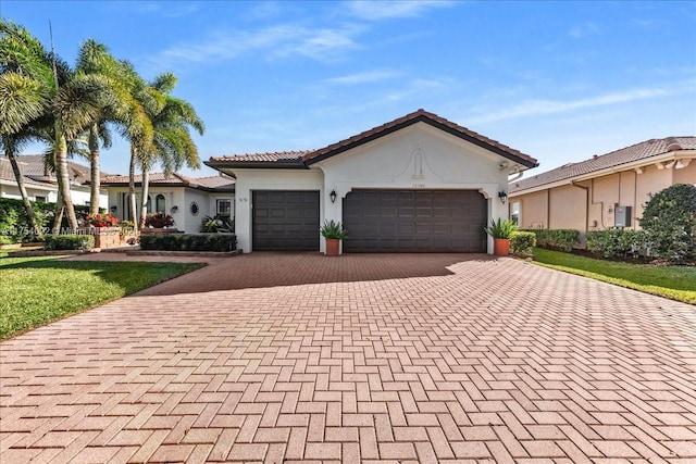 view of front facade featuring a garage, decorative driveway, a tile roof, and stucco siding