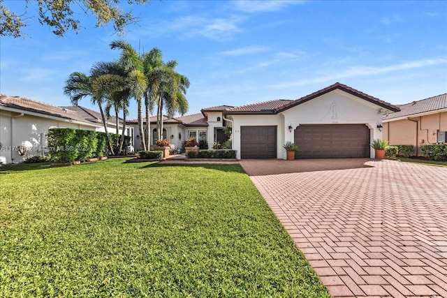 mediterranean / spanish-style house featuring a garage, a tiled roof, decorative driveway, stucco siding, and a front lawn