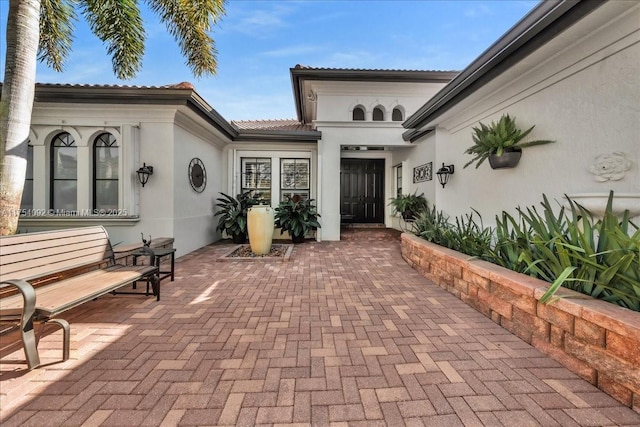 property entrance featuring a patio area and stucco siding