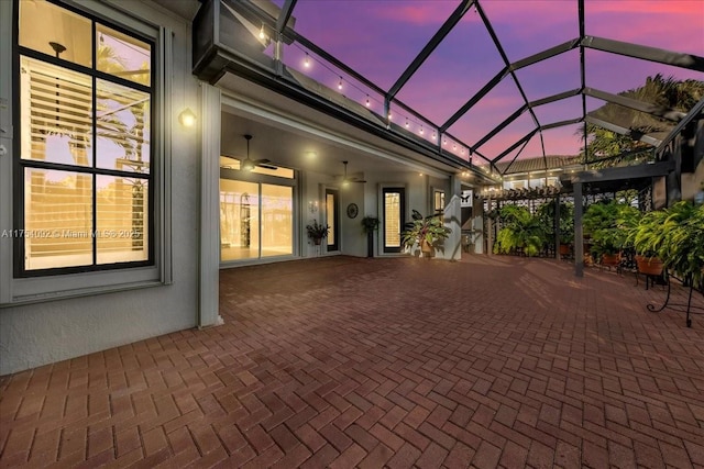 view of patio / terrace featuring glass enclosure and a ceiling fan