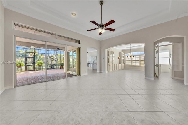 empty room with plenty of natural light, crown molding, and light tile patterned floors