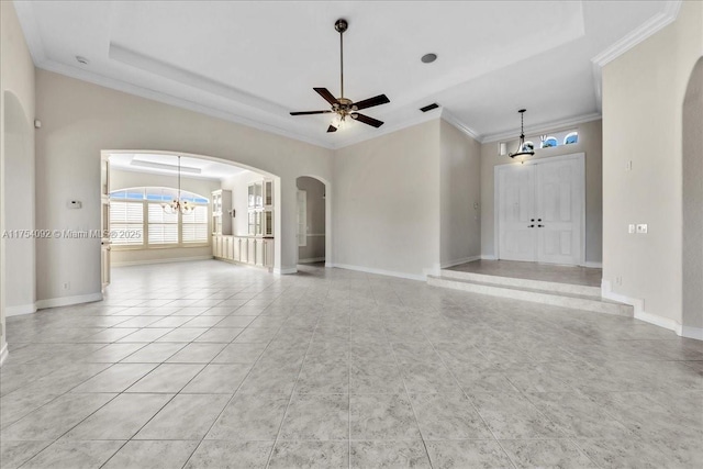 unfurnished living room featuring ornamental molding, arched walkways, baseboards, and ceiling fan with notable chandelier