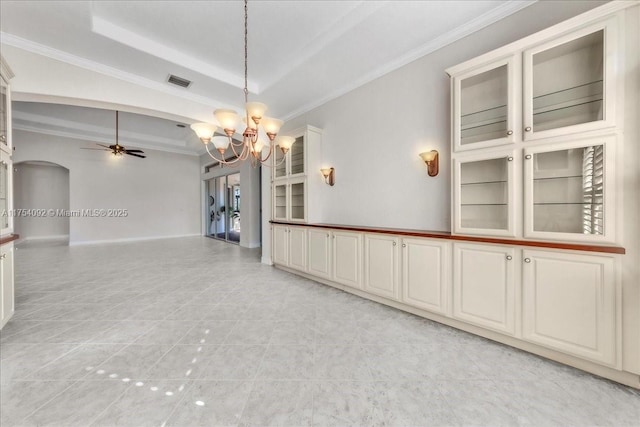 unfurnished room with visible vents, arched walkways, ornamental molding, a tray ceiling, and ceiling fan with notable chandelier