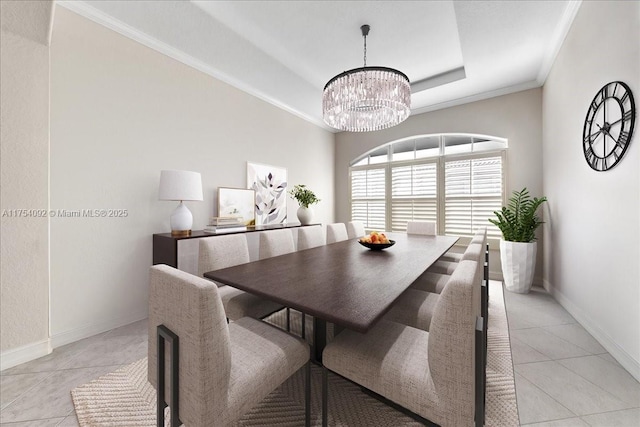 dining room featuring a notable chandelier, a raised ceiling, ornamental molding, light tile patterned flooring, and baseboards