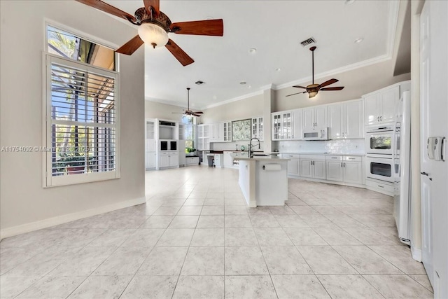 kitchen featuring white appliances, visible vents, backsplash, and ornamental molding