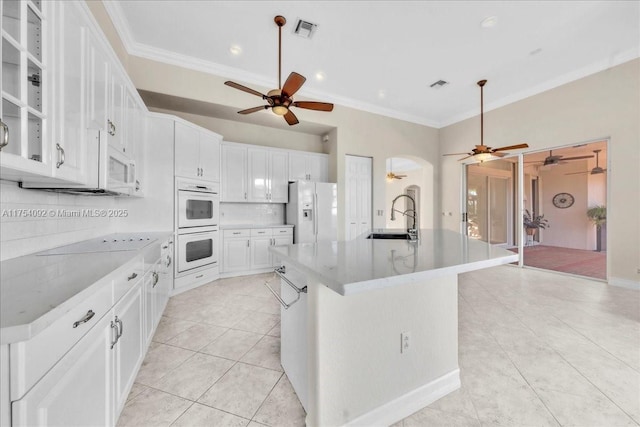 kitchen with crown molding, white appliances, visible vents, and a sink