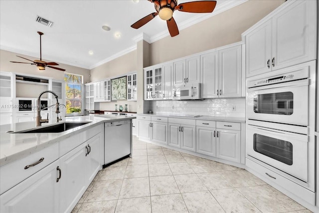 kitchen with white appliances, visible vents, decorative backsplash, crown molding, and white cabinetry