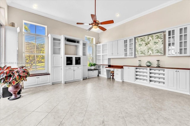 living room with ceiling fan, light tile patterned flooring, recessed lighting, ornamental molding, and built in study area