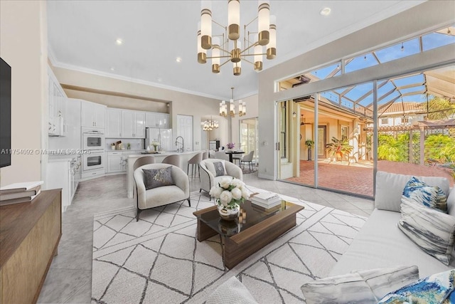 living room with a notable chandelier, recessed lighting, ornamental molding, a sunroom, and light tile patterned flooring