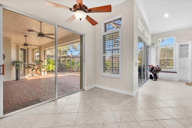 doorway with tile patterned flooring, a wealth of natural light, and baseboards