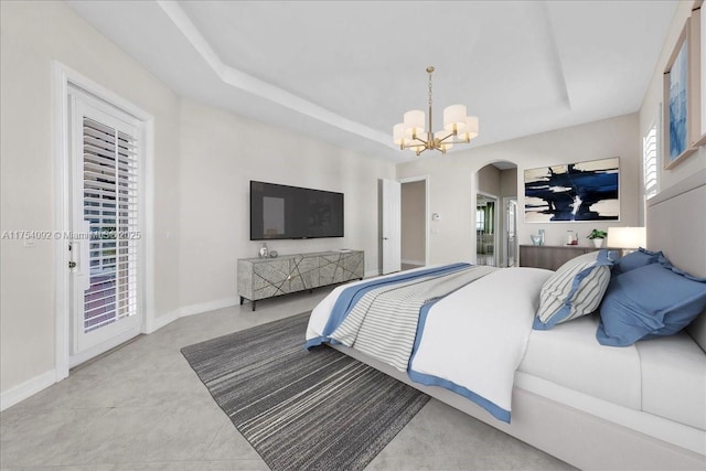 bedroom featuring arched walkways, a raised ceiling, a chandelier, access to outside, and baseboards