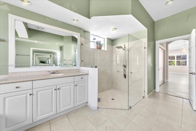 bathroom with tile patterned flooring, a shower stall, vanity, and a healthy amount of sunlight