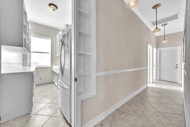 hall featuring light tile patterned floors, ornamental molding, visible vents, and baseboards