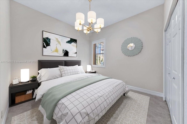 bedroom featuring a closet, a notable chandelier, and baseboards