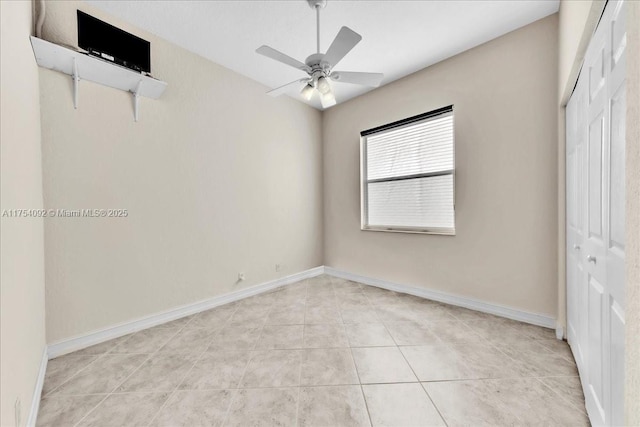 interior space with light tile patterned floors, ceiling fan, a closet, and baseboards