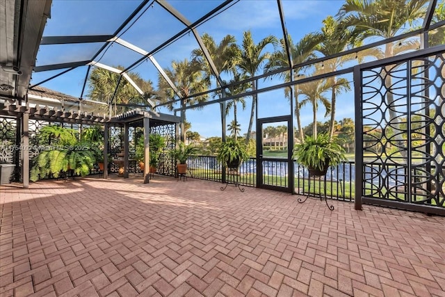 view of patio featuring a water view and a lanai