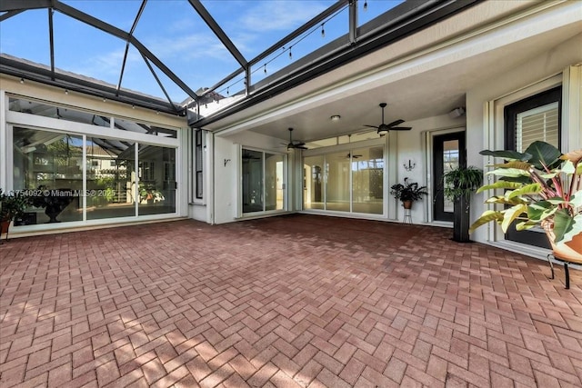 exterior space featuring glass enclosure and ceiling fan