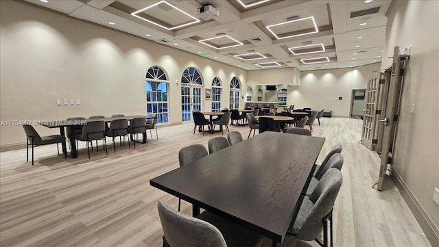 dining room with visible vents, a high ceiling, light wood-style floors, coffered ceiling, and baseboards