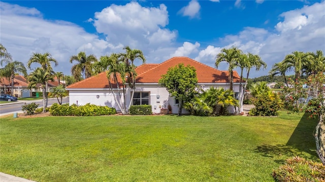 mediterranean / spanish-style home featuring stucco siding, a front lawn, and a tile roof