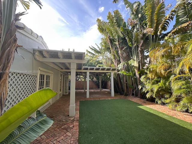 view of yard featuring a patio area, a fenced backyard, and a pergola