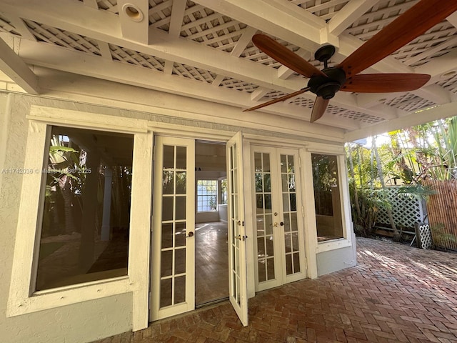 unfurnished sunroom with a ceiling fan and french doors