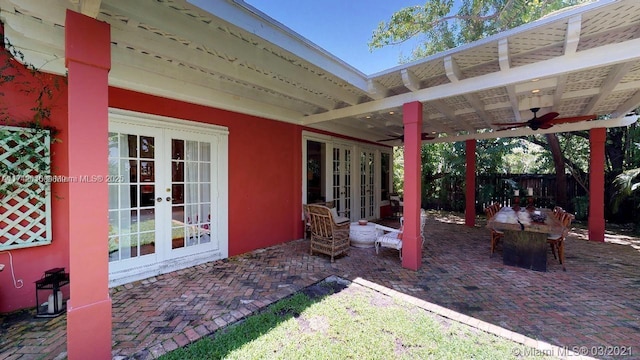 view of patio with french doors, fence, and a ceiling fan