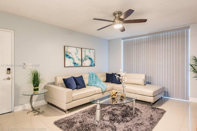 living room with ceiling fan, a textured ceiling, tile patterned flooring, and baseboards