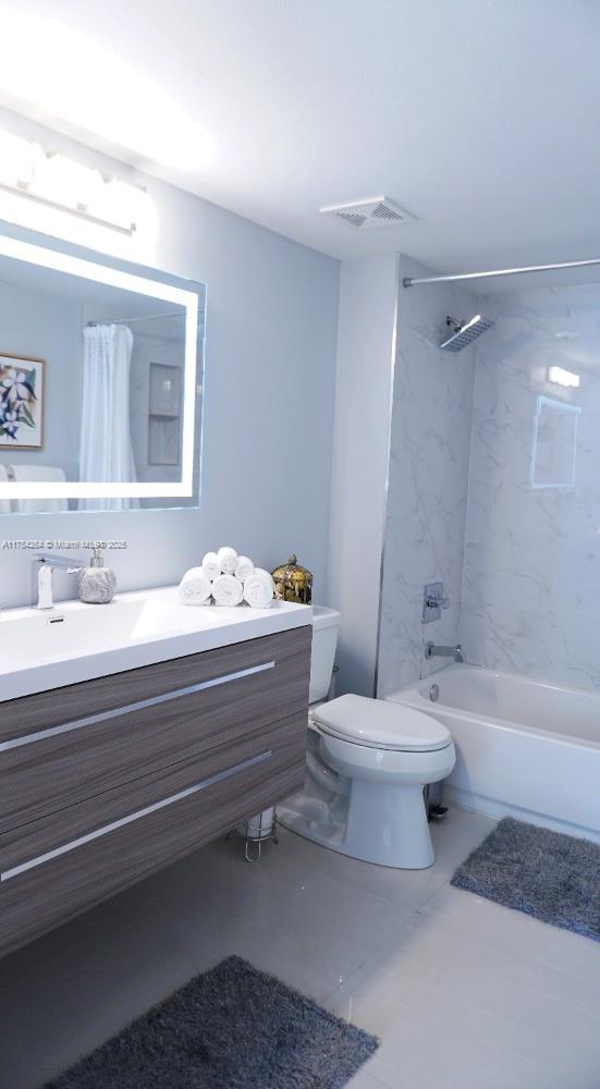 bathroom with toilet, visible vents, shower / bath combo with shower curtain, and vanity