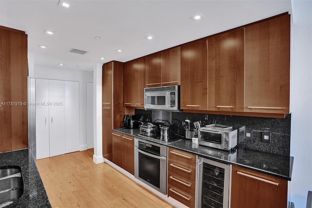 kitchen with wine cooler, a toaster, stainless steel appliances, visible vents, and light wood-type flooring