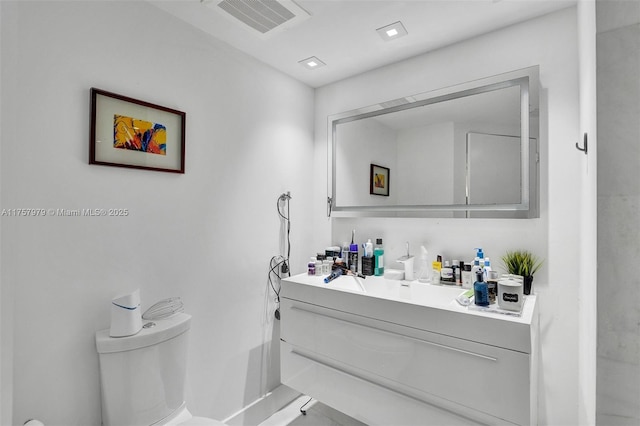 bathroom featuring toilet, visible vents, and vanity