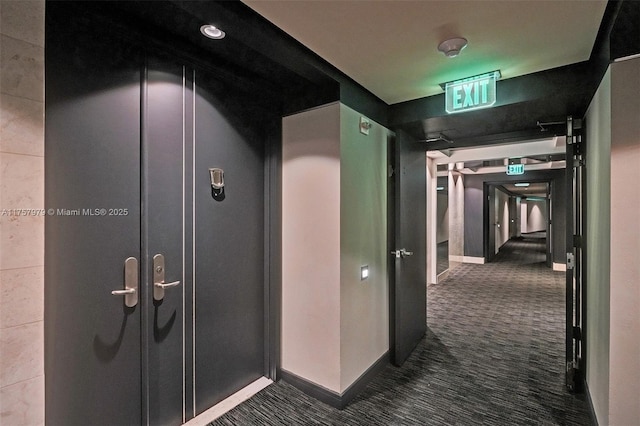 hallway featuring carpet and baseboards