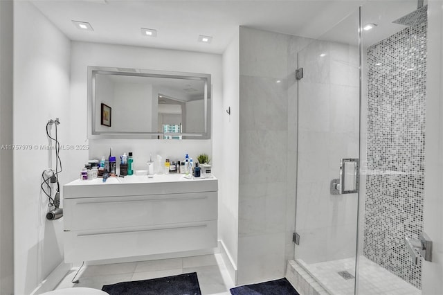 bathroom with tile patterned flooring, a shower stall, and vanity