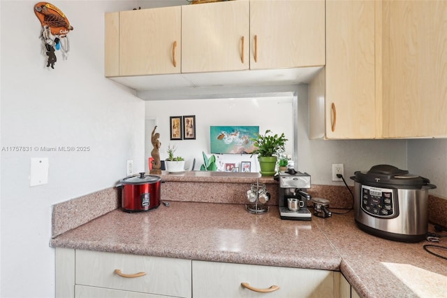 kitchen with light countertops and light brown cabinetry