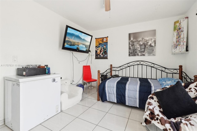 bedroom with light tile patterned floors, fridge, and a ceiling fan