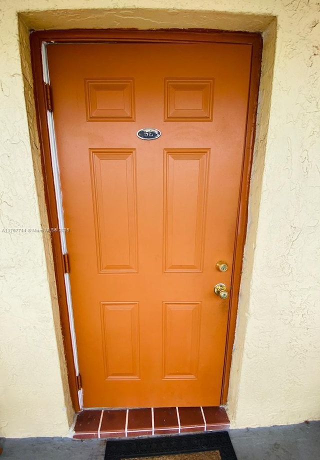 property entrance with stucco siding