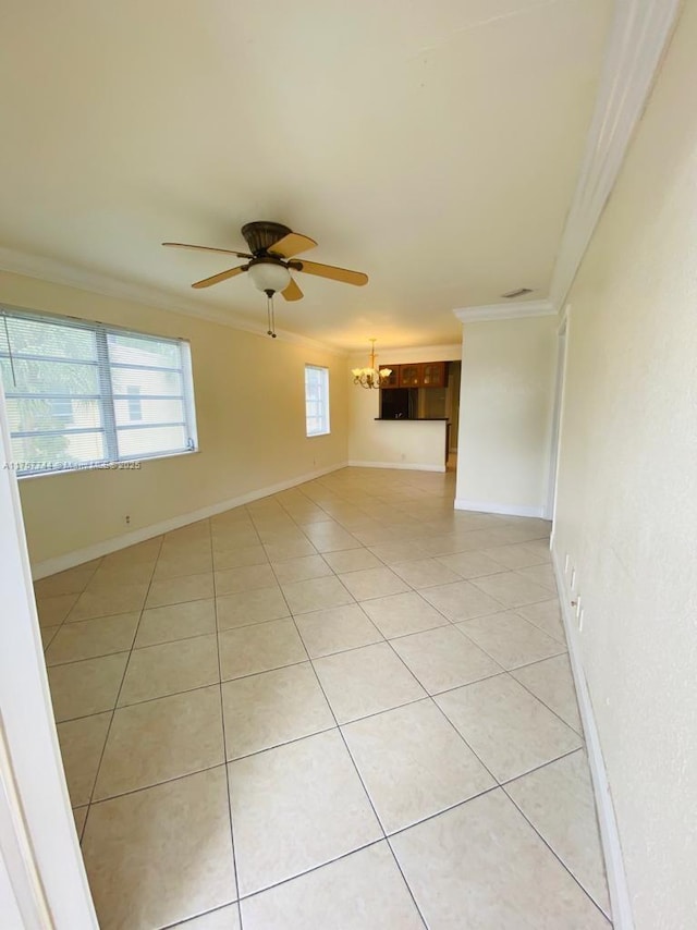 spare room with crown molding, baseboards, and light tile patterned floors