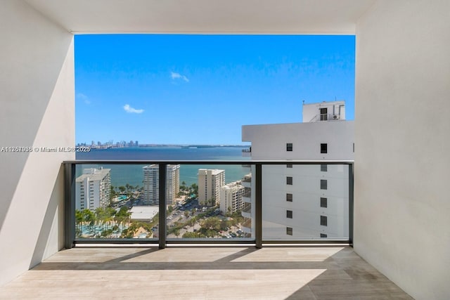 balcony featuring a water view and a city view