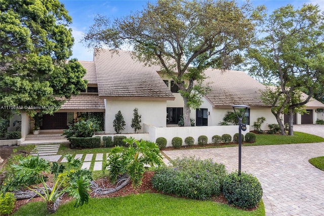 view of front of property featuring decorative driveway and stucco siding