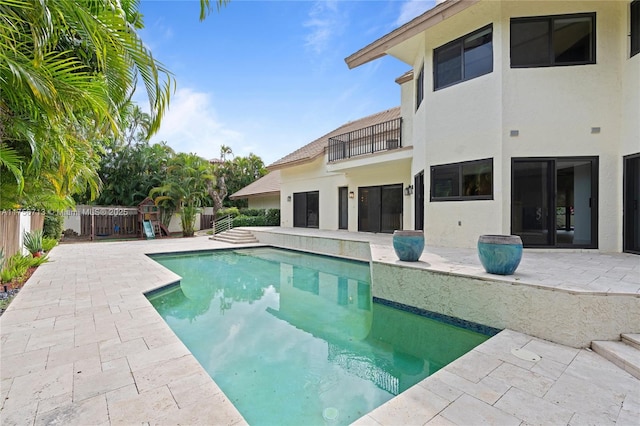 view of pool featuring a playground, a patio area, a fenced backyard, and a fenced in pool