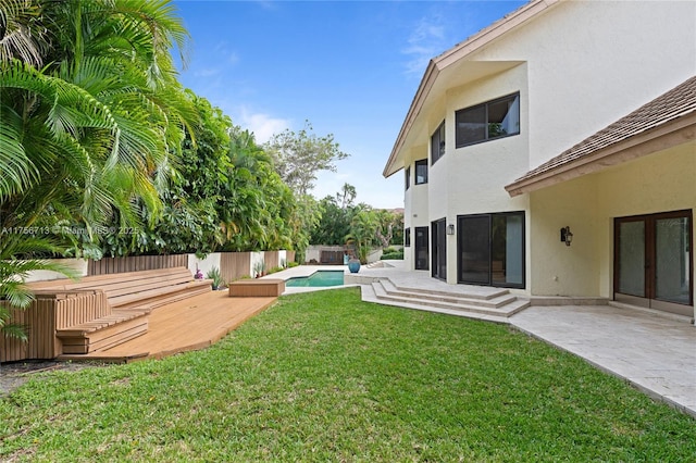 view of yard featuring a fenced in pool, french doors, a patio area, fence, and a wooden deck