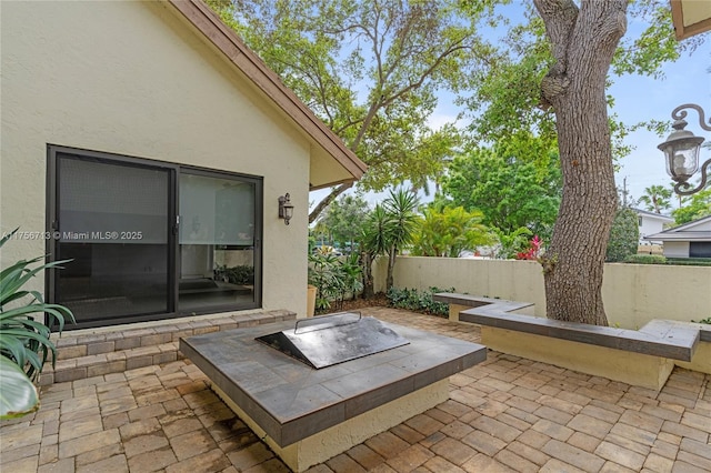 view of patio / terrace featuring an outdoor fire pit and fence