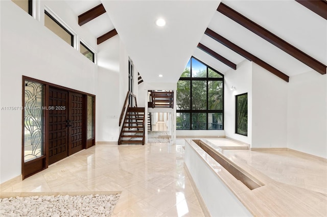 foyer entrance with stairs, marble finish floor, beamed ceiling, and high vaulted ceiling