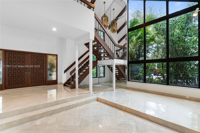 interior space featuring a towering ceiling and stairs